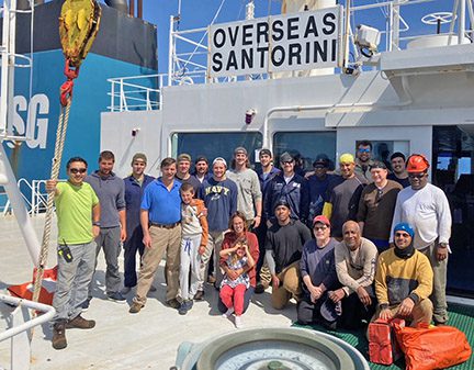 Mariners from the Overseas Santorini and the people they rescued gather for a photo on deck